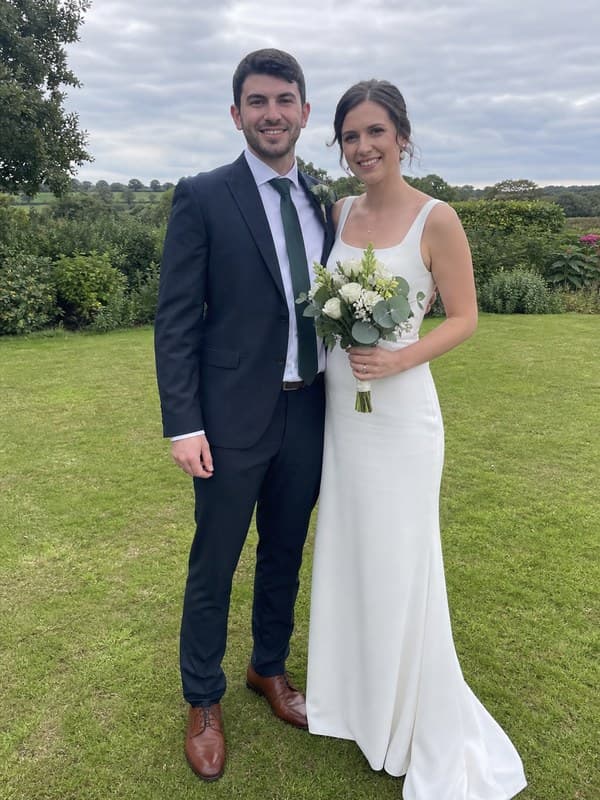 Photo of a bride and groom standing together outdoors on an overcast day