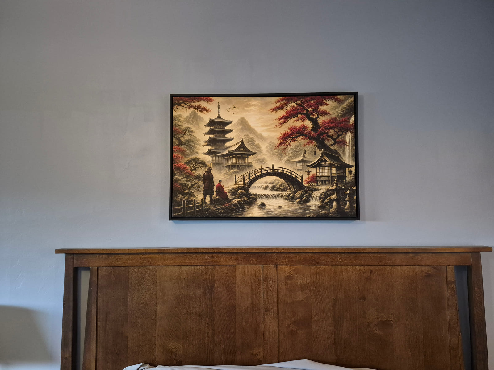 A framed canvas painting of a samurai and a monk, hanging on a customer's wall